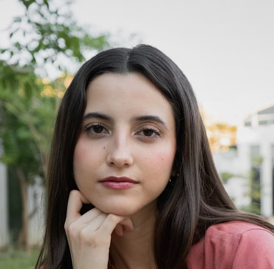 Woman with straight dark hair resting hand on chin